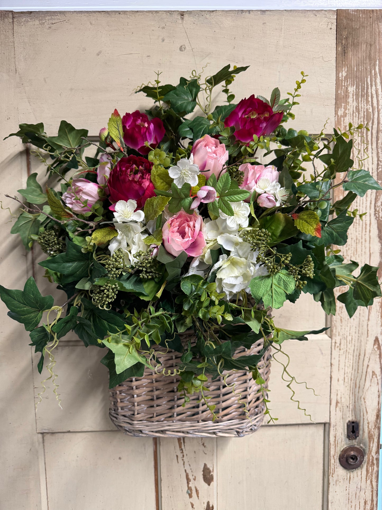 Maisie Basket Arrangement with soft pink and raspberry peonies, white hydrangeas, and cascading ivy in a rustic woven basket"