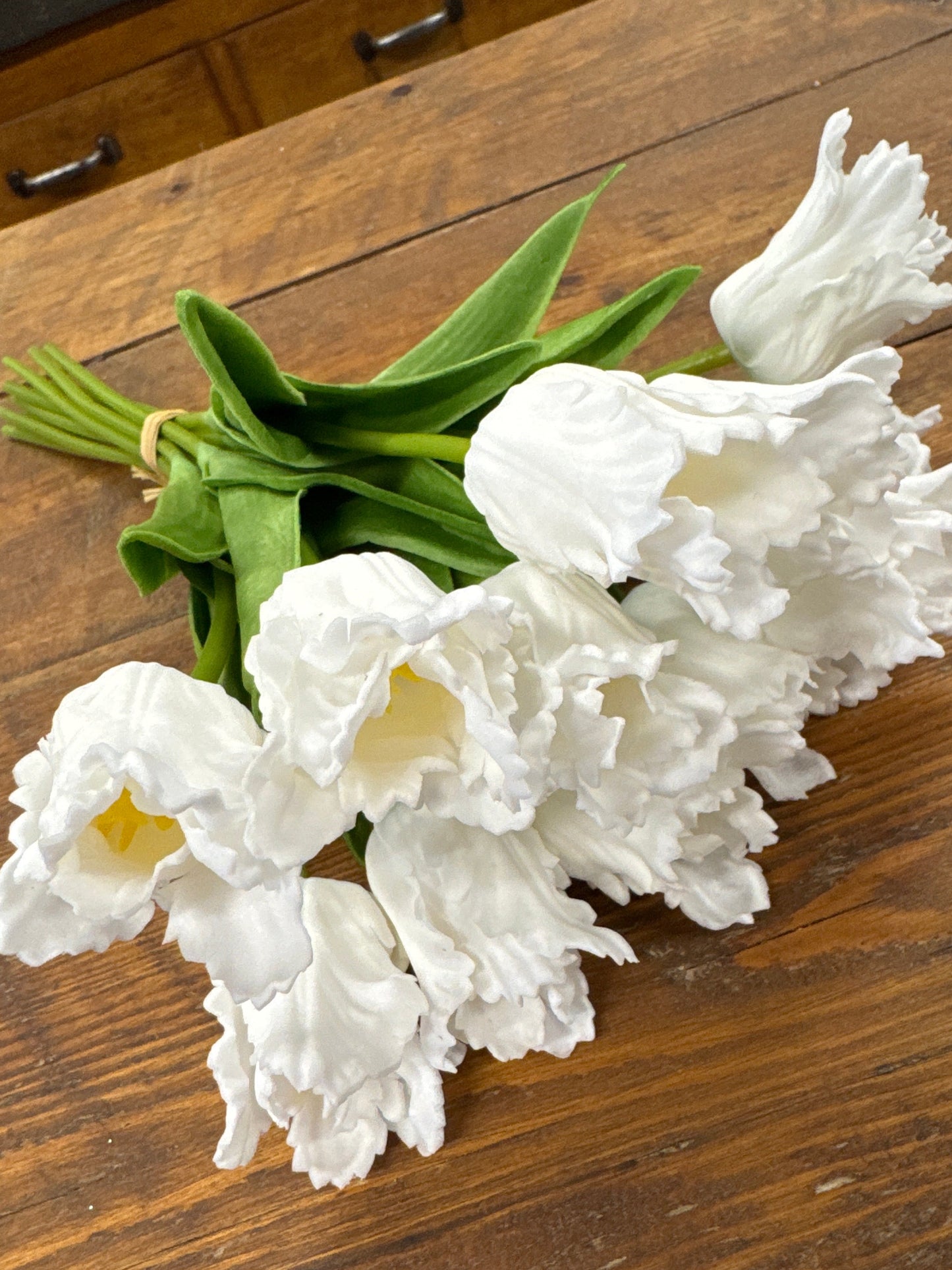 Bouquet of white tulips on a wooden surface