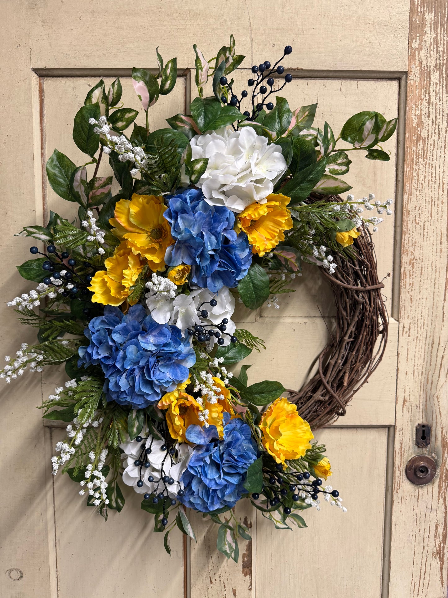 Sienna Skye crescent wreath with warm-toned faux florals and lush greenery in a crescent shape, perfect for front doors and earthy elegant home decor"