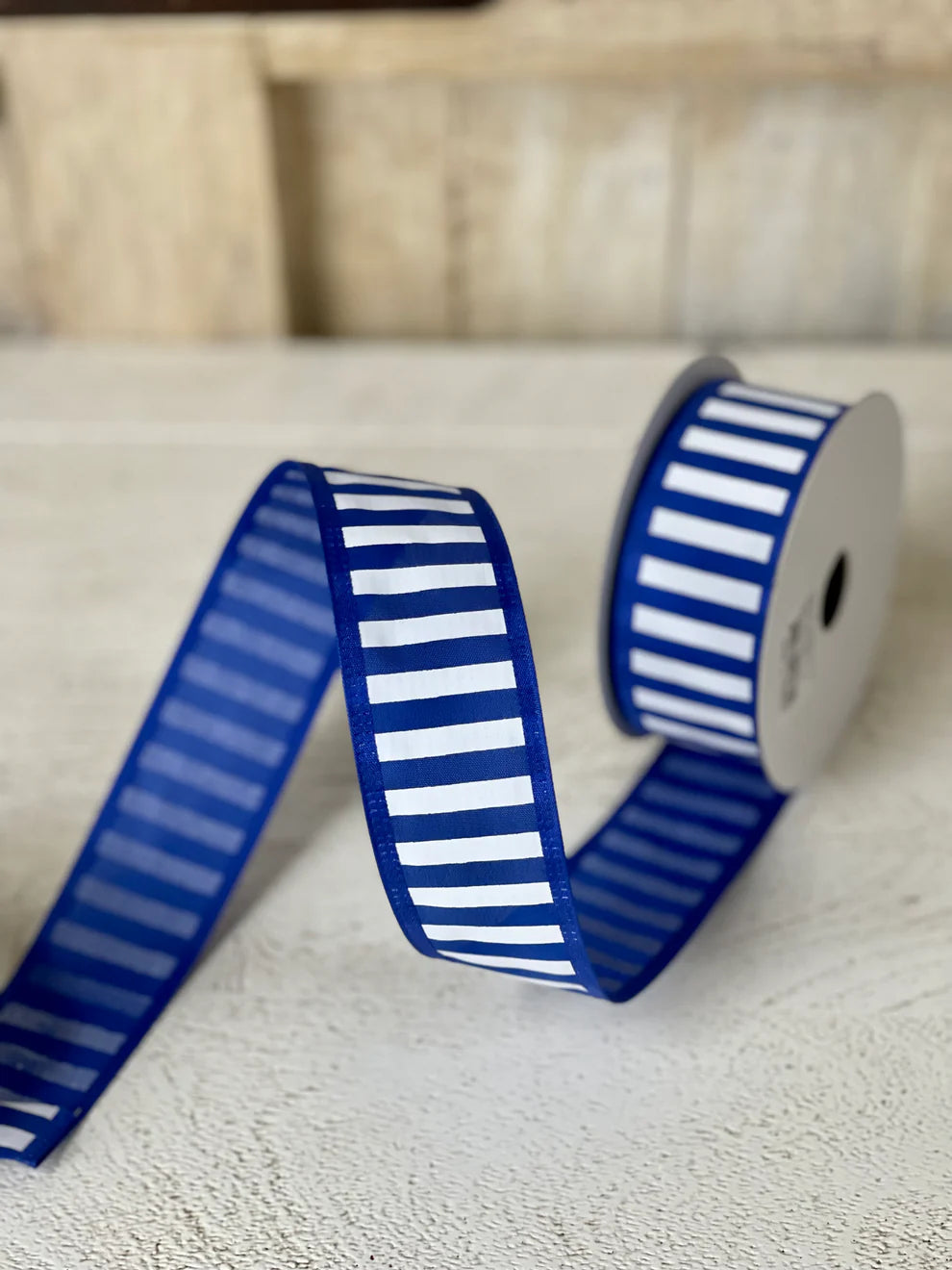 1.5 inch by 10 yard royal blue and white striped ribbon rolled on a spool, ideal for wreaths and floral arrangements"