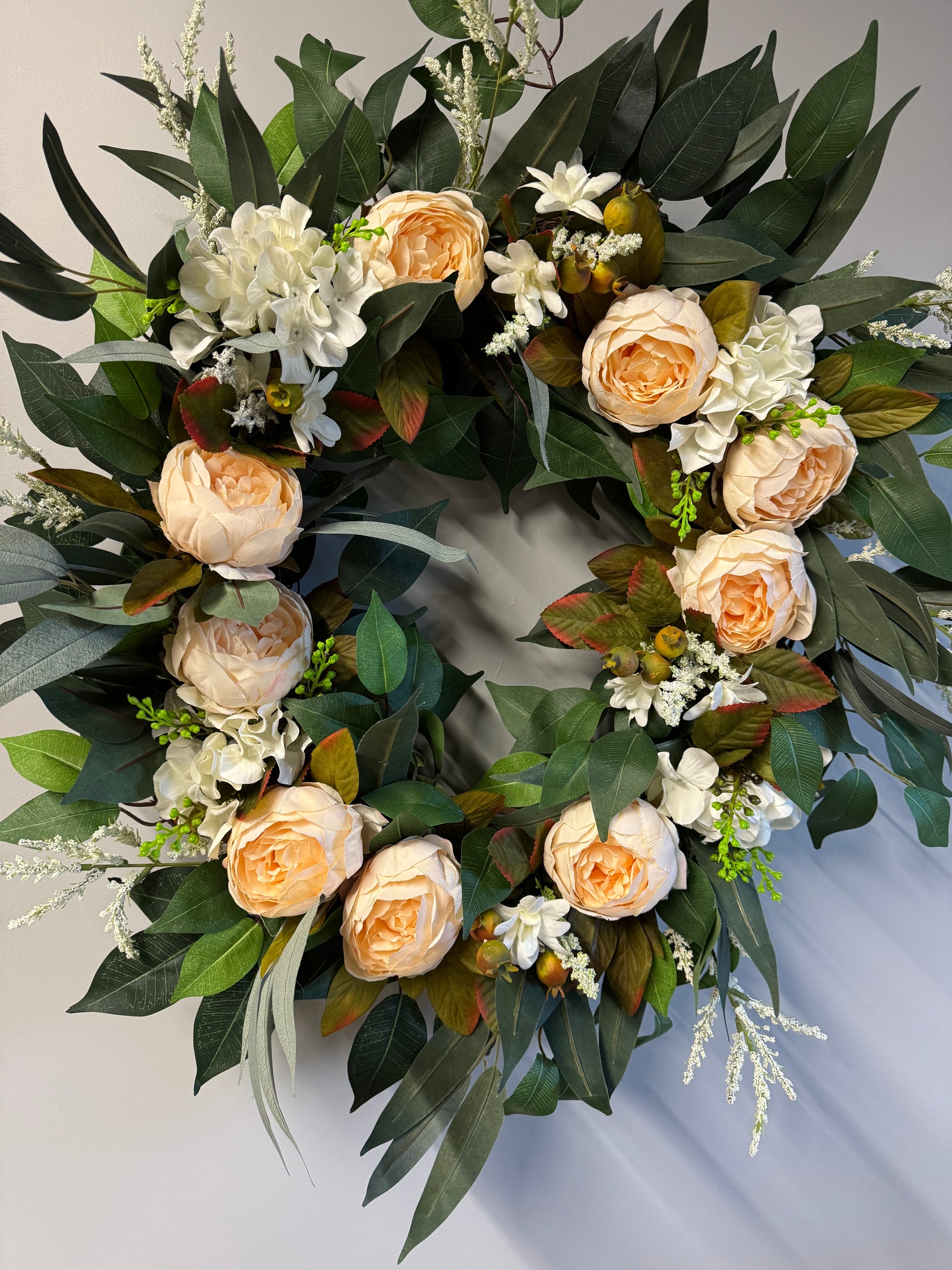 Handcrafted wreath featuring lush eucalyptus and soft peonies. 