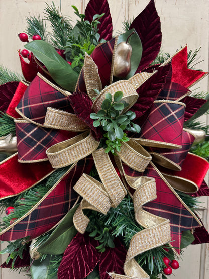 close up of Christmas swag detail with red berries, gold pears, green magnolia leaves, pine, boxwood, and burgundy leaves.”