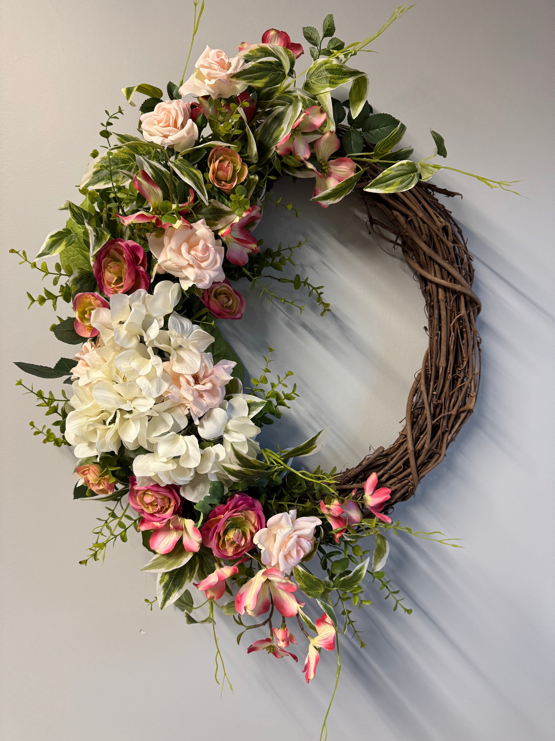 Handcrafted garden romance wreath featuring premium florals and greenery. 