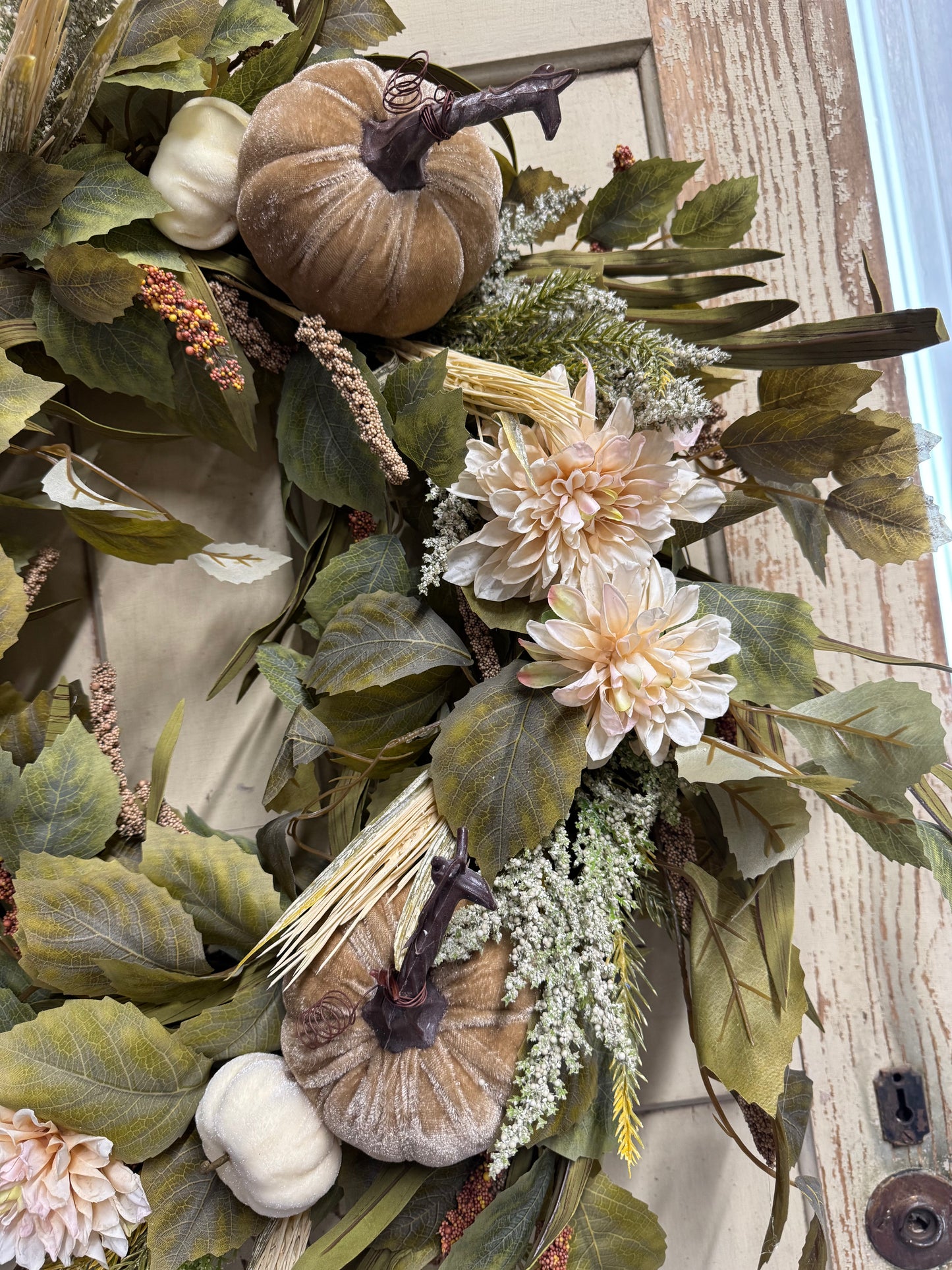 Clara Jane neutral fall wreath with champagne velvet pumpkins, cream dahlias, birch foliage, and wheat accents displayed on a rustic white door"