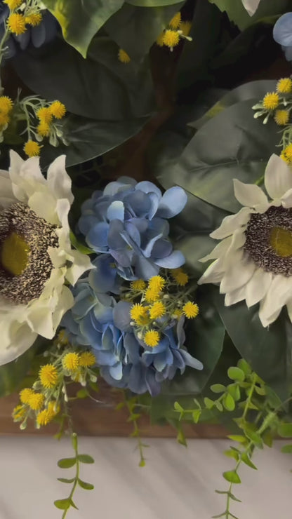 video of Sunny blue hydrangea wreath with white sunflowers and yellow baby's breath on rustic wood frame for front door"