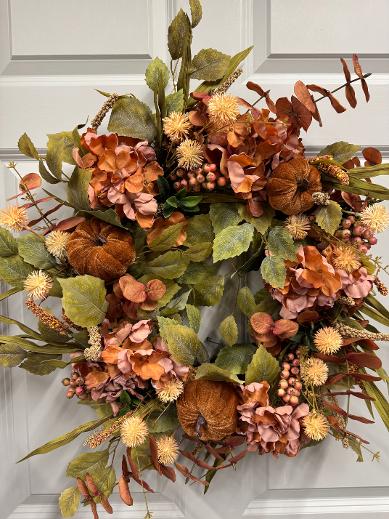 24-inch fall wreath with rust velvet pumpkins, coral berries, green birch leaves, rust eucalyptus, hydrangeas, and thistle.”