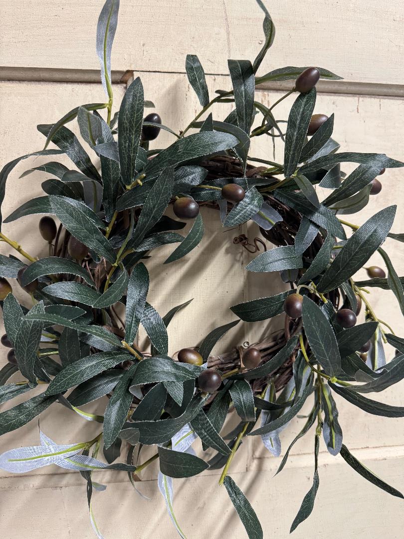 Olive branch candle ring with faux olive branches and small olives arranged in a ring, perfect for pillar candles and Mediterranean-inspired table centerpieces"