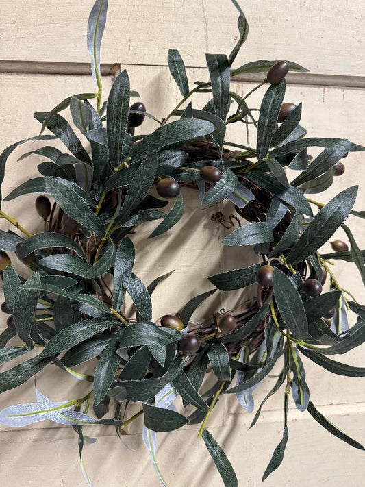 Olive branch candle ring with faux olive branches and small olives arranged in a ring, perfect for pillar candles and Mediterranean-inspired table centerpieces"